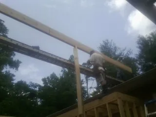 Carpenter setting a ridge beam over a new addition frame — Ice Dam Removal by Roofing Brothers in Bethel Springs