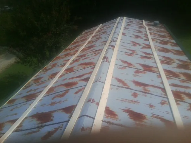 Rusted metal roof panels with new wood purlins before replacement — Storm Damage Roof Repair in Bethel Springs by Roofing Brothers