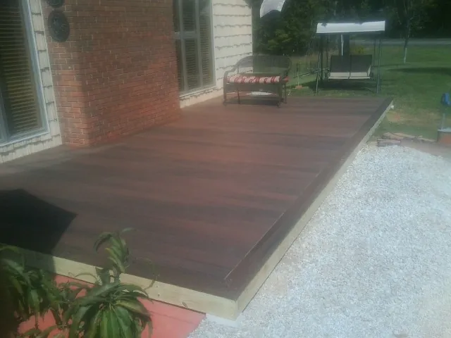 Freshly stained wood deck built against a brick home in Bethel Springs