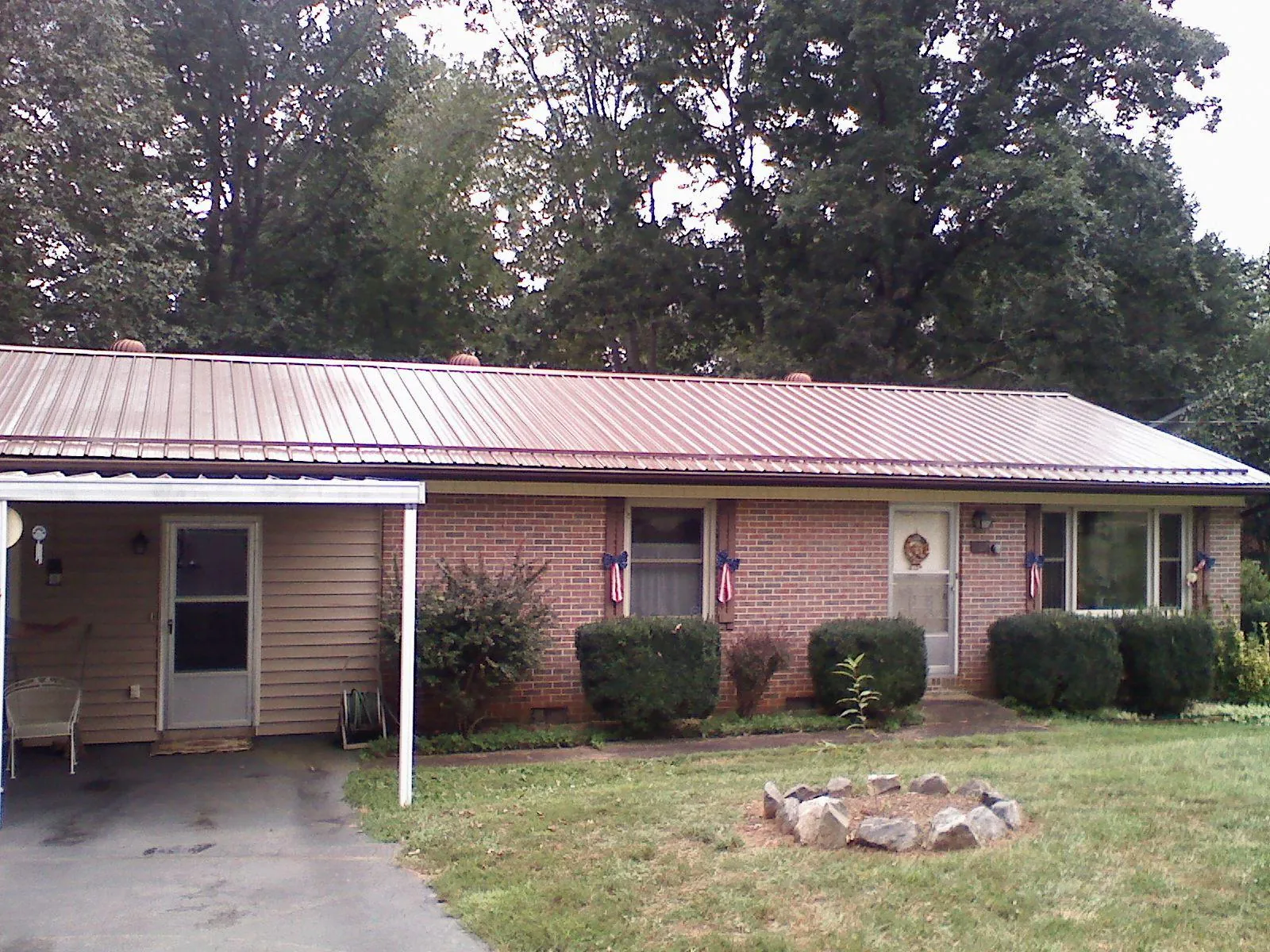 Bronze metal roof and carport on a brick ranch home — Roof Repair work by our crew in Bethel Springs